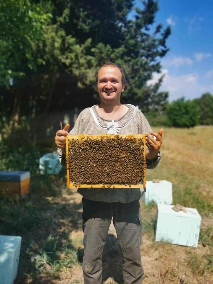 Mathieu Ripert sans voile avec un cadre d'abeilles